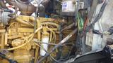 A close-up of a yellow engine from a 2003 International 5600i showing various pipes wires and components in a complex arrangement