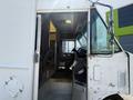 A 2012 Ford Econoline with an open door revealing the driver's seat and dashboard inside the cabin