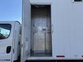 A 2011 Freightliner M2 106 truck with a white exterior featuring an open metal cargo door revealing a clean metallic interior space with no visible cargo