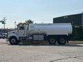 A 2008 Peterbilt 340 truck with a large white tank mounted on the back, featuring six wheels and a cab with side equipment compartments