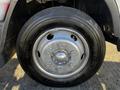 A silver wheel with six lug nuts and a black tire attached to a 2014 Mitsubishi Fuso FE
