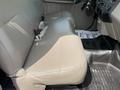 Tan leather seats in the front row of a 2008 Ford F-250 SD with seatbelt buckles visible and a rubber floor mat below