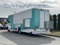 A 2020 Freightliner MT45 delivery truck featuring a light blue and white exterior with a side serving window and a rear access door