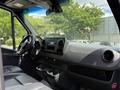 Interior of a 2022 Mercedes-Benz Sprinter showing the dashboard steering wheel and control panel with cup holders visible