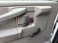 Close-up of the interior door handle and locking mechanism of a 2015 GMC Savana with a manual window crank and an unlock button