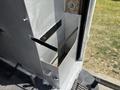 A metal storage compartment attached to a vehicle, featuring a rectangular shape with a horizontal bar for support and a handle on the side for access