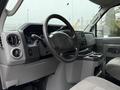 Interior view of a 2013 Ford Econoline showcasing the steering wheel dashboard controls and center console