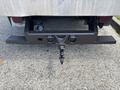A rear view of a 2020 Chevrolet Silverado showing a black hitch and towing apparatus attached to the bumper