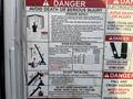 A 2010 Ford F-550 with safety operation and hazard warning stickers attached to its door detailing safety procedures and precautions