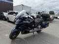 A 2016 Yamaha FJR1300AE motorcycle in dark blue with a large rear trunk and a touring style design standing on a paved surface
