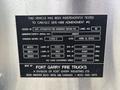 A metal plate with details about a 2002 GMC C7500 vehicle includes testing information, manufacturer's serial number, and specifications for performance and RPM limits
