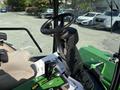 Interior view of a 2021 John Deere 1575 featuring the steering wheel control panel and seat with various operating controls visible