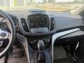 Interior of a 2014 Ford Escape featuring a dashboard with a touchscreen display and gear shift in the center console
