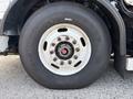Close-up of a large tire mounted on a wheel of a 2011 Autocar Xpeditor showing distinctive tread pattern and lug nut design