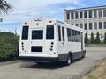 A 2020 Chevrolet Express bus in white with a black lower section featuring multiple windows and rear lights