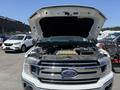 A 2019 Ford F-150 with its hood raised displaying the engine and various components under the hood