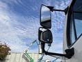 A 2013 Freightliner 114SD truck with prominent side mirrors reflecting the sky