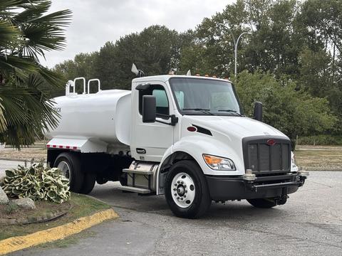 A white 2025 Peterbilt 536 truck designed for transport with a cylindrical tank attached to the rear and visible headlights and grille details