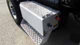 A metallic step and fuel tank on a 2003 International 5600i truck with a diamond plate pattern and a red cap