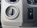 The control panel of a 2013 Ford E-350 Super Duty featuring a round knob for headlight settings and a switch for interior lights