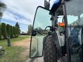 A 2009 New Holland T4020 tractor with an open door showing the interior and a large front tire visible