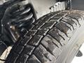 Close-up of a tire with a detailed tread pattern showing dirt and debris on a 2018 Ford Econoline