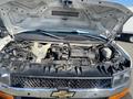 A 2011 Chevrolet Express with its hood open revealing the engine compartment and various mechanical components