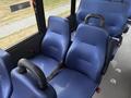 Two blue fabric seats with armrests inside a vehicle