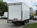 A 2018 Hino 195 box truck with a white exterior and a closed rear door parked in a lot