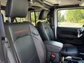 Interior view of a 2021 Jeep Wrangler with black leather seats featuring red Rubicon branding on the headrests and a modern dashboard