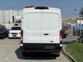 A white 2022 Ford Transit van viewed from the rear with a smooth exterior and taillights visible