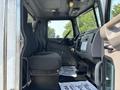 Interior view of a 2020 Peterbilt 330 featuring two black seats and a dashboard with controls and a display panel