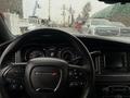 View of the steering wheel and dashboard of a 2017 Dodge Charger with the Dodge logo prominently displayed and instrumentation visible