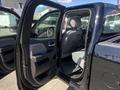 A 2014 GMC Sierra 1500 with an open driver's side door revealing the interior and seated driver's position