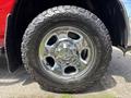 Close-up of a chrome wheel rim and thick all-terrain tire on a 2013 RAM 2500 vehicle