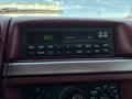 The dashboard of a 1995 Ford F-250 featuring a radio and climate control knobs with a digital clock displaying 8:02