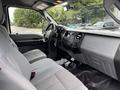 Interior of a 2013 Ford F-250 SD featuring gray fabric seats and a dashboard with various controls and storage compartments