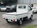A 2008 Suzuki Carry pickup truck with a compact design and an open cargo bed located at the back