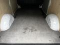 Interior view of a 2020 Mercedes-Benz Metris showing a spacious cargo area with grey vinyl flooring and rounded wheel wells on each side