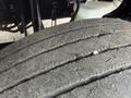 Close-up of a worn tire from a 2021 Freightliner M2 106 showing visible tread wear and small debris embedded in the rubber surface