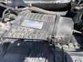Close-up of the engine compartment of a 2020 Chevrolet Express showing the Vortec engine cover with dust and components around it