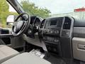 Interior of a 2019 Ford F-350 SD featuring a dashboard with control buttons a touchscreen display and a steering wheel with controls