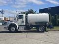 White 2022 Freightliner M2 106 truck with a large round tank mounted on the back parked on a concrete surface