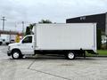 A 2022 Ford E-450 box truck with a white exterior and a cargo box, parked on a paved surface with a clear profile view