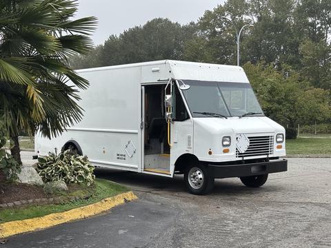 A white 2012 Ford E-450 Super Duty box truck with an open side door and a distinctive front grille design