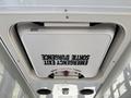 A white emergency exit hatch labeled "EMERGENCY EXIT" located on the ceiling of a 2020 Chevrolet Express