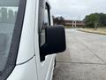 A 2008 Suzuki Carry with a side mirror visible in the foreground, showcasing a compact design and a white exterior