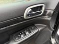 Interior door panel of a 2019 Jeep Grand Cherokee with control buttons for windows and locks