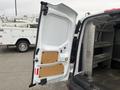A 2017 Ford Transit Connect with its rear door open, revealing a spacious cargo area with shelves and a clean interior
