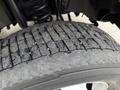 Close-up of a worn tire from a 2020 Ford F-550 showing tread patterns and debris lodged in the grooves